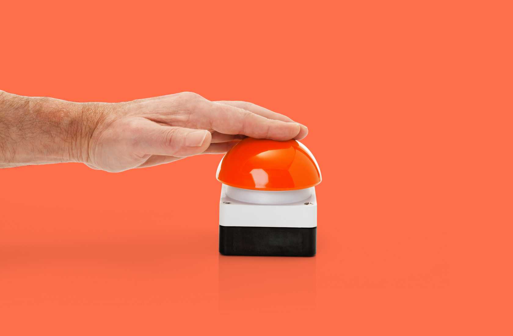 A hand that is about to press a buzzer